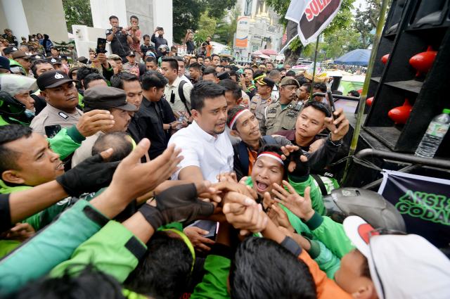 Gubernur Sumut Muhammad Bobby Afif Nasution menemui dan mendengarkan keluhan para driver ojek online (Ojol) roda dua, yang melakukan unjuk rasa di depan Kantor Gubernur Sumut, Jalan Diponegoro 30 Medan, Selasa (20/5/2025). Gabungan Ojek Roda Dua Medan Sekitar (GODAMS) yang menggelar ‘Aksi Damai 205’ memprotes kebijakan aplikator yang dianggap merugikan para driver online. Foto/Diskominfo Sumut